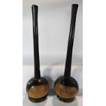 A pair of extremely heavy South African Knobkerrie, balanced on circular wood dishes. 48cm overall.