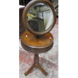 A Victorian walnut shaving stand with adjustable circular mirror raised on turned column and tripod