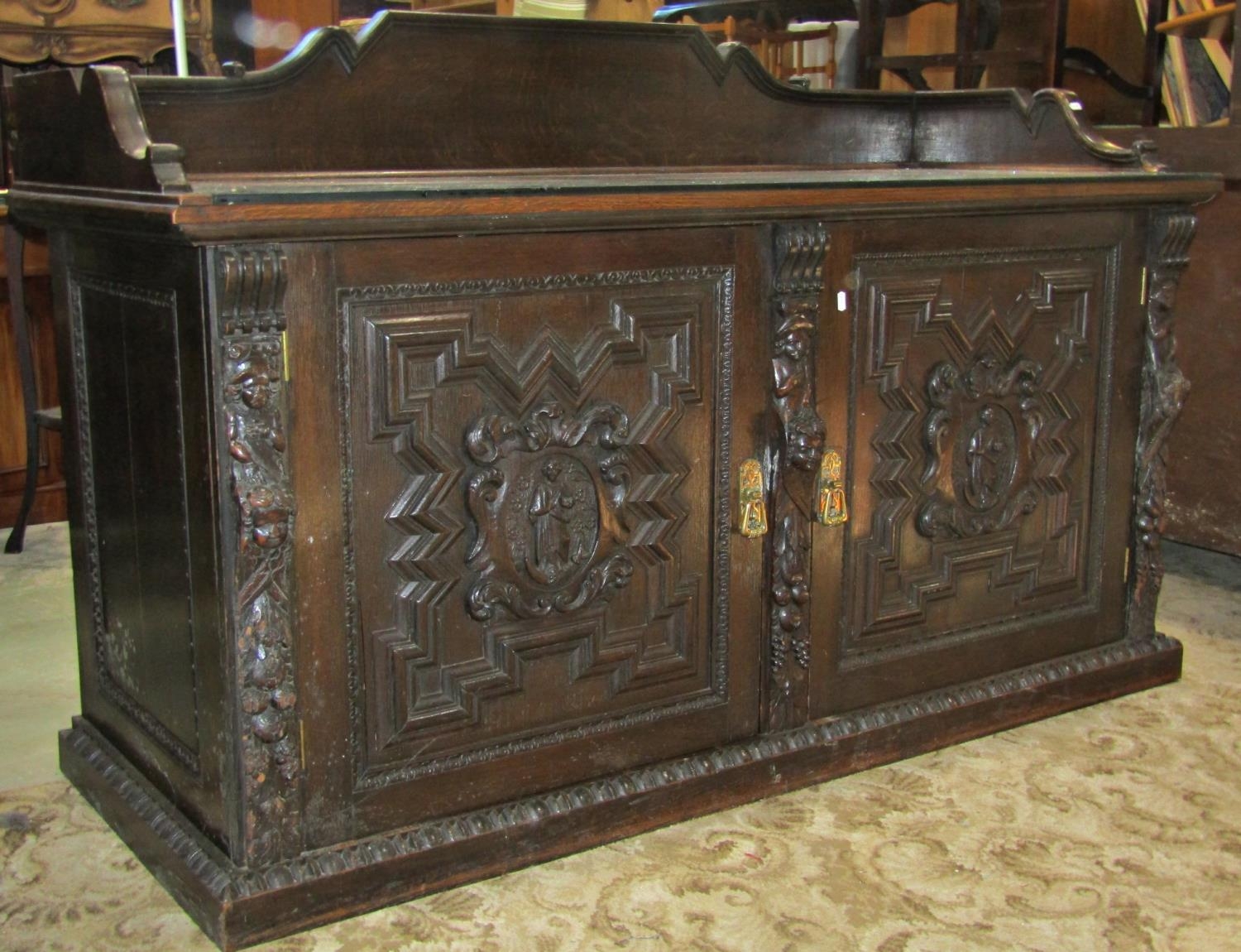 A substantial 19th century oak side cupboard enclosed by a pair of panelled doors, oval portrait