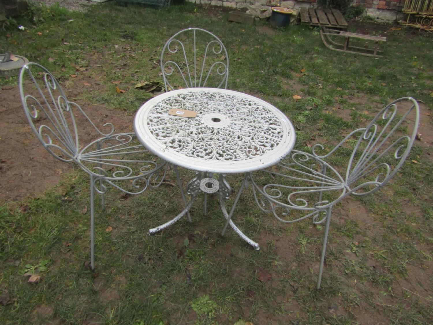 A cast aluminium garden terrace table with pierced scrolling foliate panelled top and swept