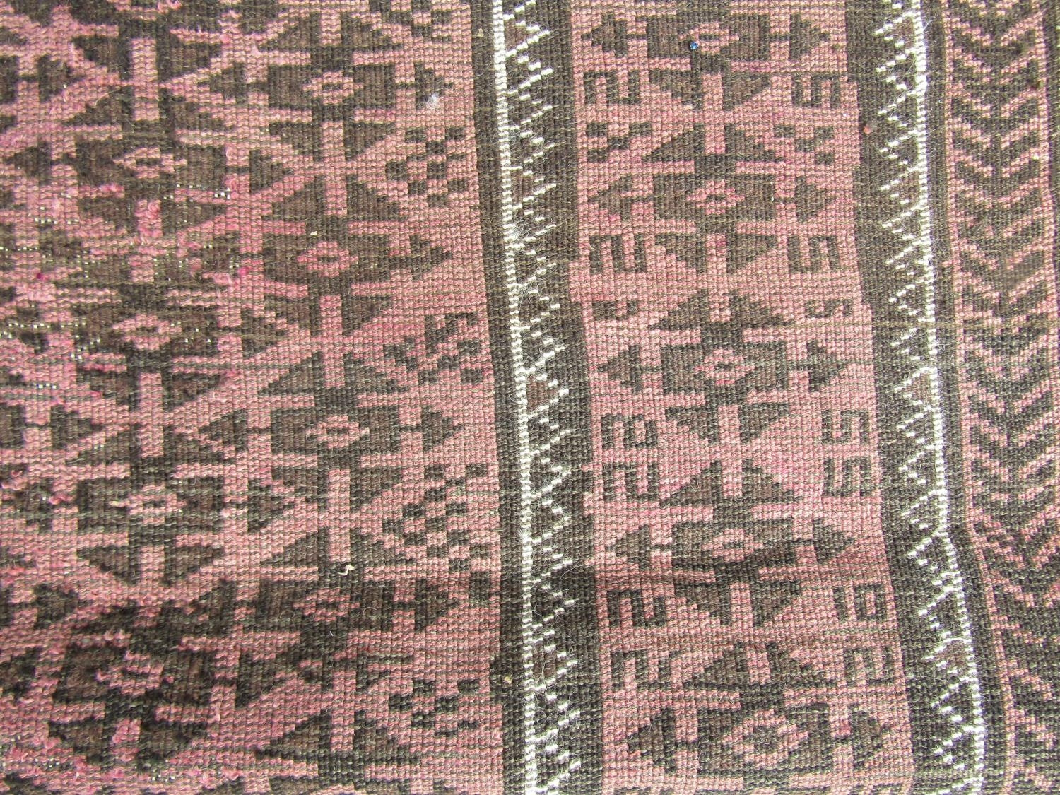 A worn Middle Eastern rug with repeated geometric design throughout in pale maroon and brown - Image 3 of 3