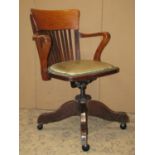 An Edwardian/1920's oak swivel office chair with pad seat