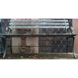 A pair of two seat garden benches with decorative cast iron end supports with open scroll detail (