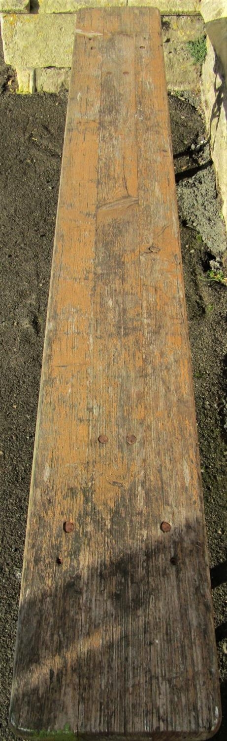 A stained trestle bench with plank seat raised on folding painted iron supports, approx 220 cm - Image 2 of 2