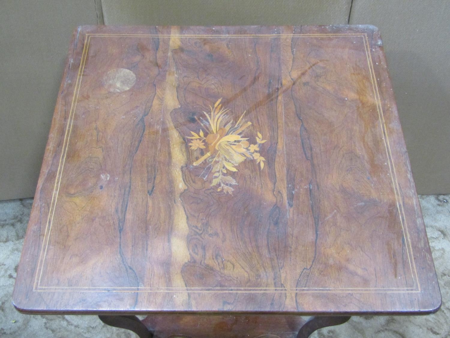 An inlaid Edwardian rosewood two tier occasional table raised on scrolled supports and castors, - Image 2 of 2