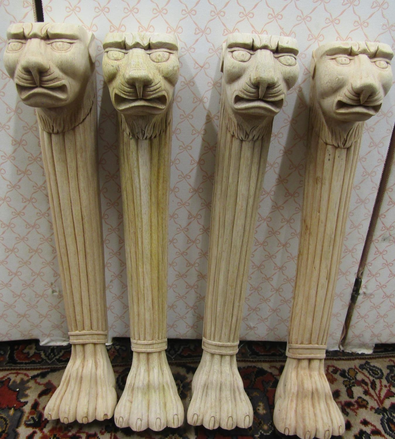 Four carved hardwood column supports with lion mask and lions paw feet, 58cm high