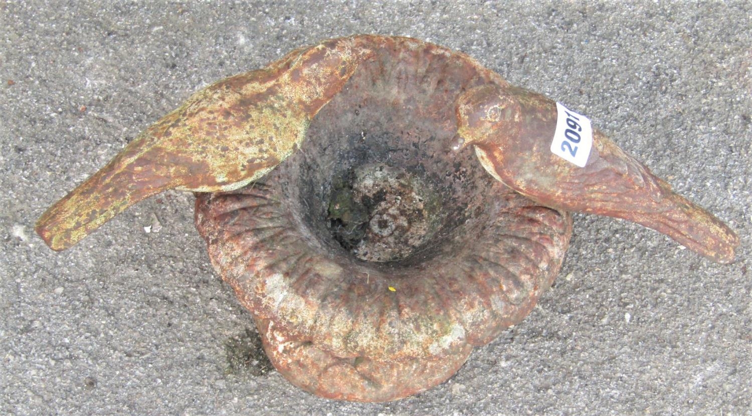 A small weathered cast iron bird bath in the form of a flared foliate urn with birds surmount, 22 cm