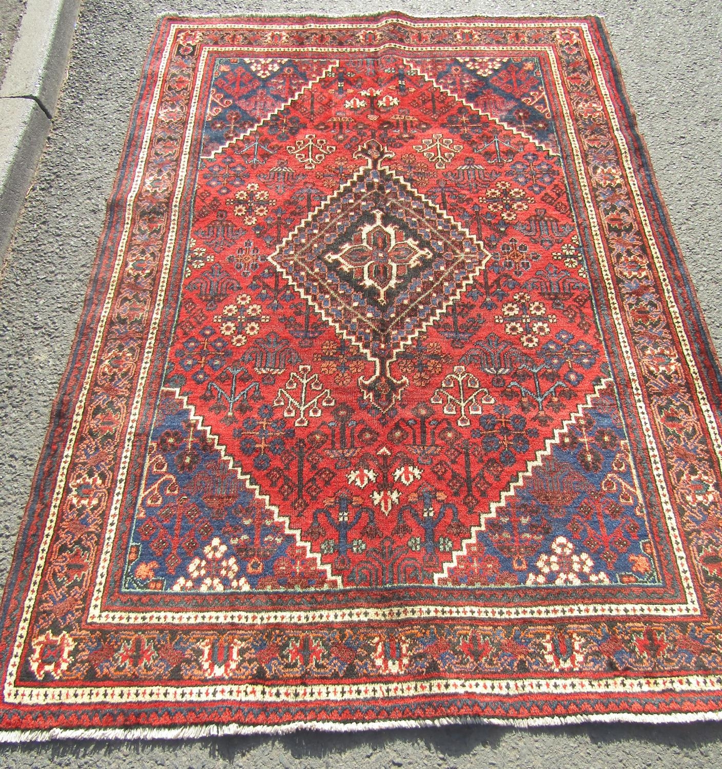 A North West Persian Josheghan rug with central diamond medallion and repeated floral patterns in