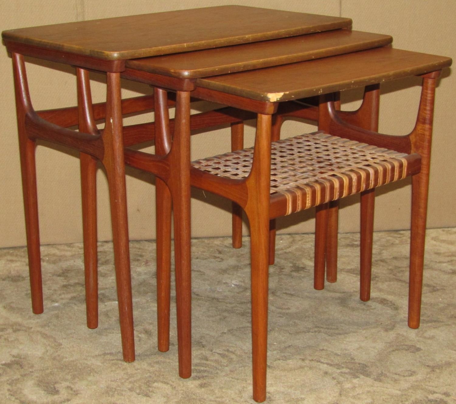 A nest of three retro Danish teak occasional tables raised on moulded tapered supports, smallest