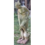 A weathered cast composition stone garden ornament in the form of a standing classical maiden, 84 cm