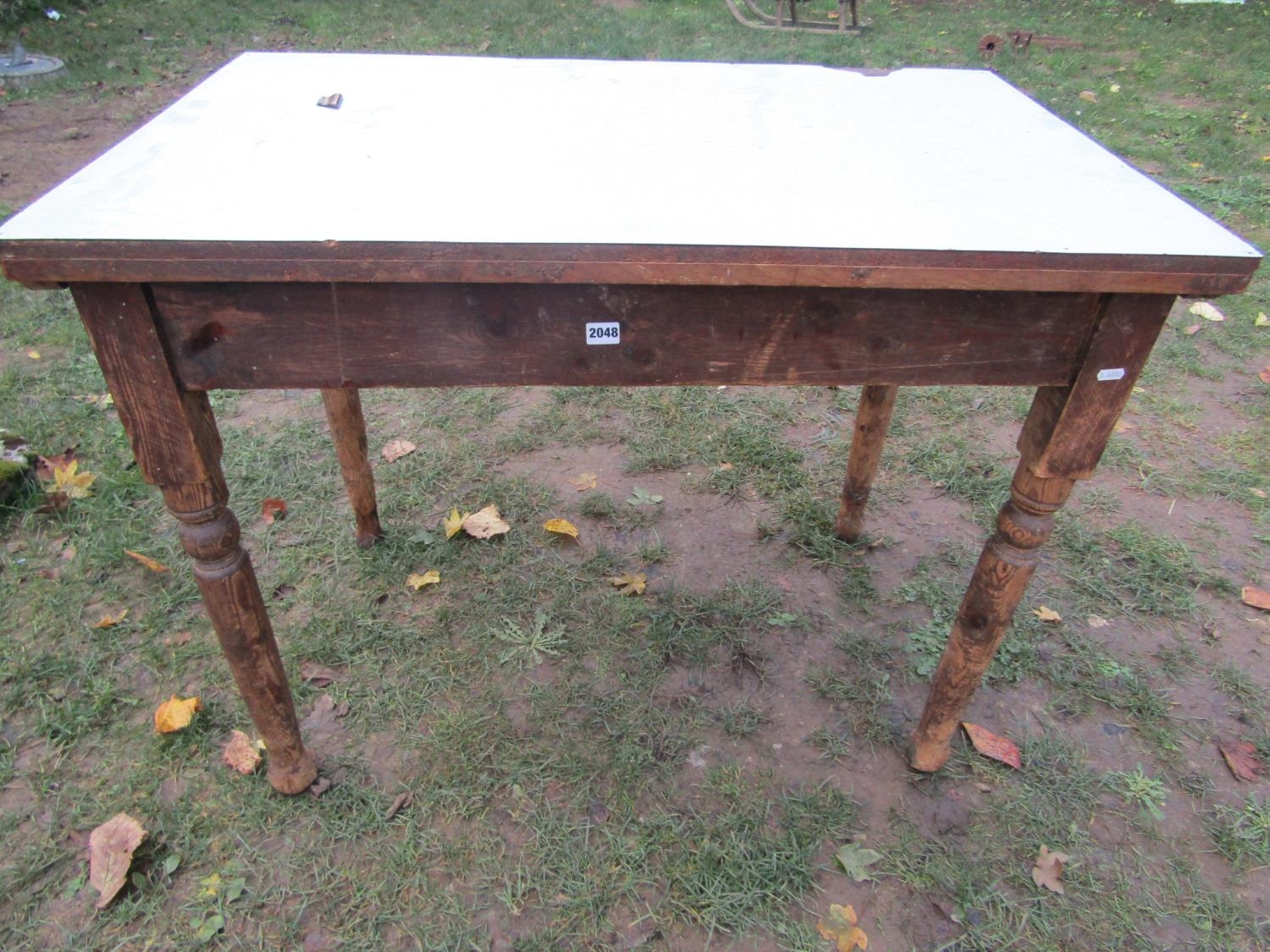 A Victorian stained pine kitchen table of rectangular form with later formica top, 107 cm x 68 cm (