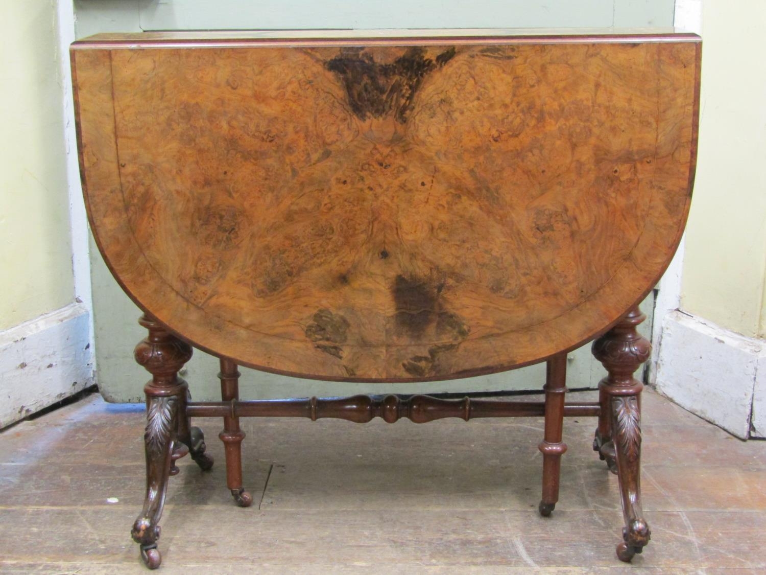 A Victorian figured walnut Sutherland tea table on carved supports, the top with simple inlaid