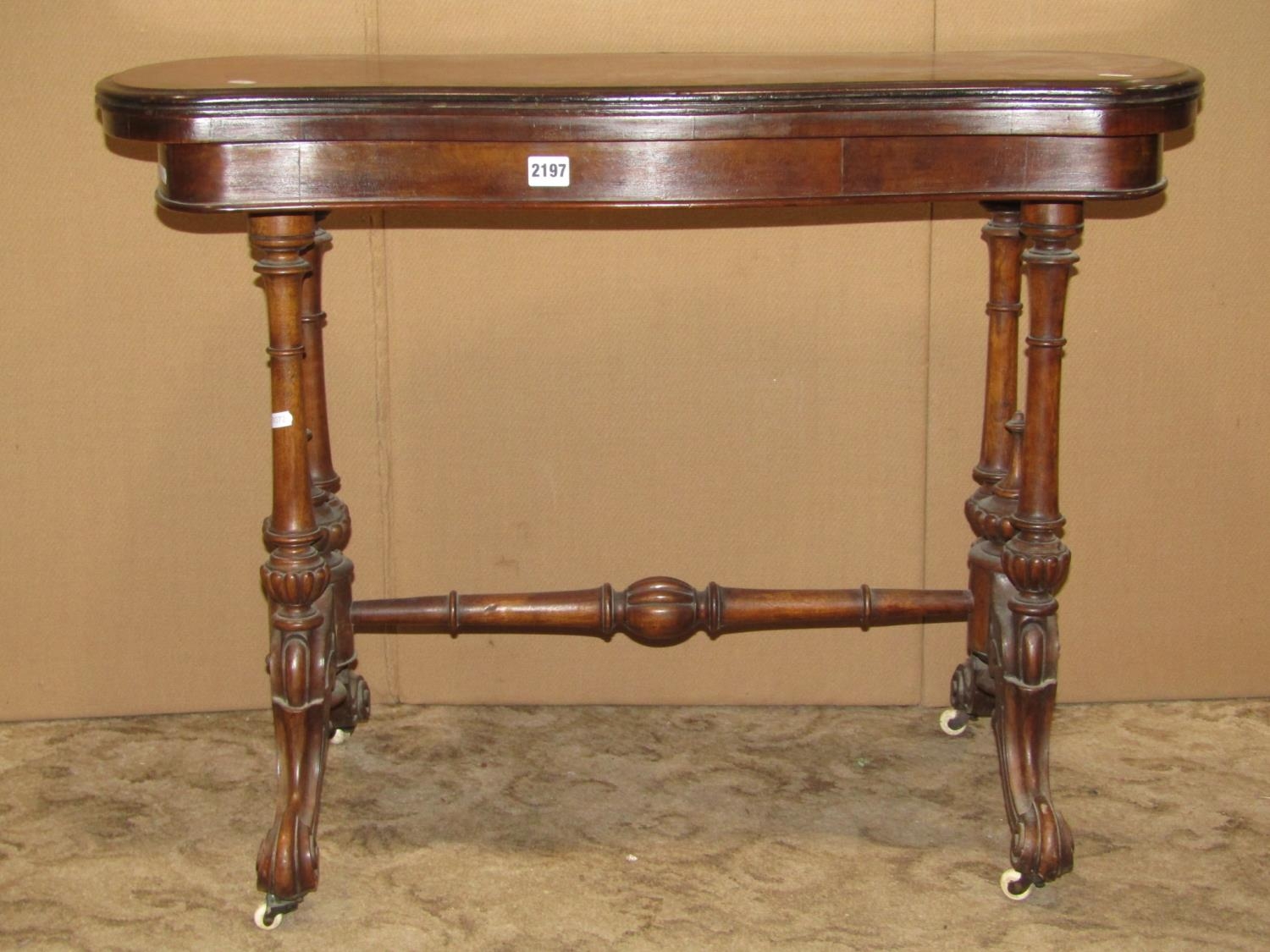 A walnut and figured walnut veneered fold over top card table with serpentine outline, raised on