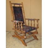 A late Victorian/Edwardian rocking chair with turned framework and carpet upholstered seat and