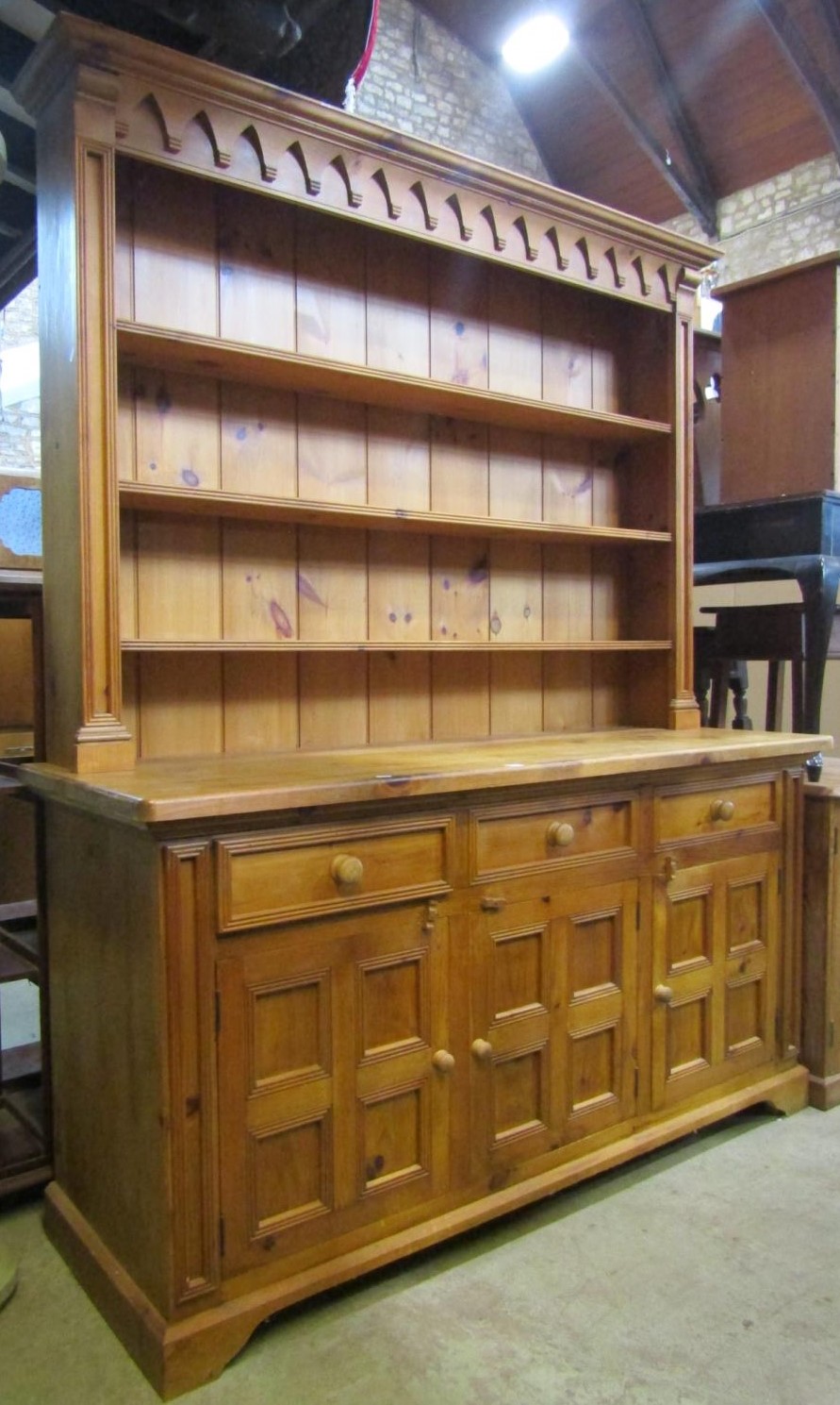 A stripped pine farmhouse kitchen dresser, the base enclosed by three square moulded panelled