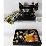 A portable Singer electric sewing machine with accessories complete with original carrying case