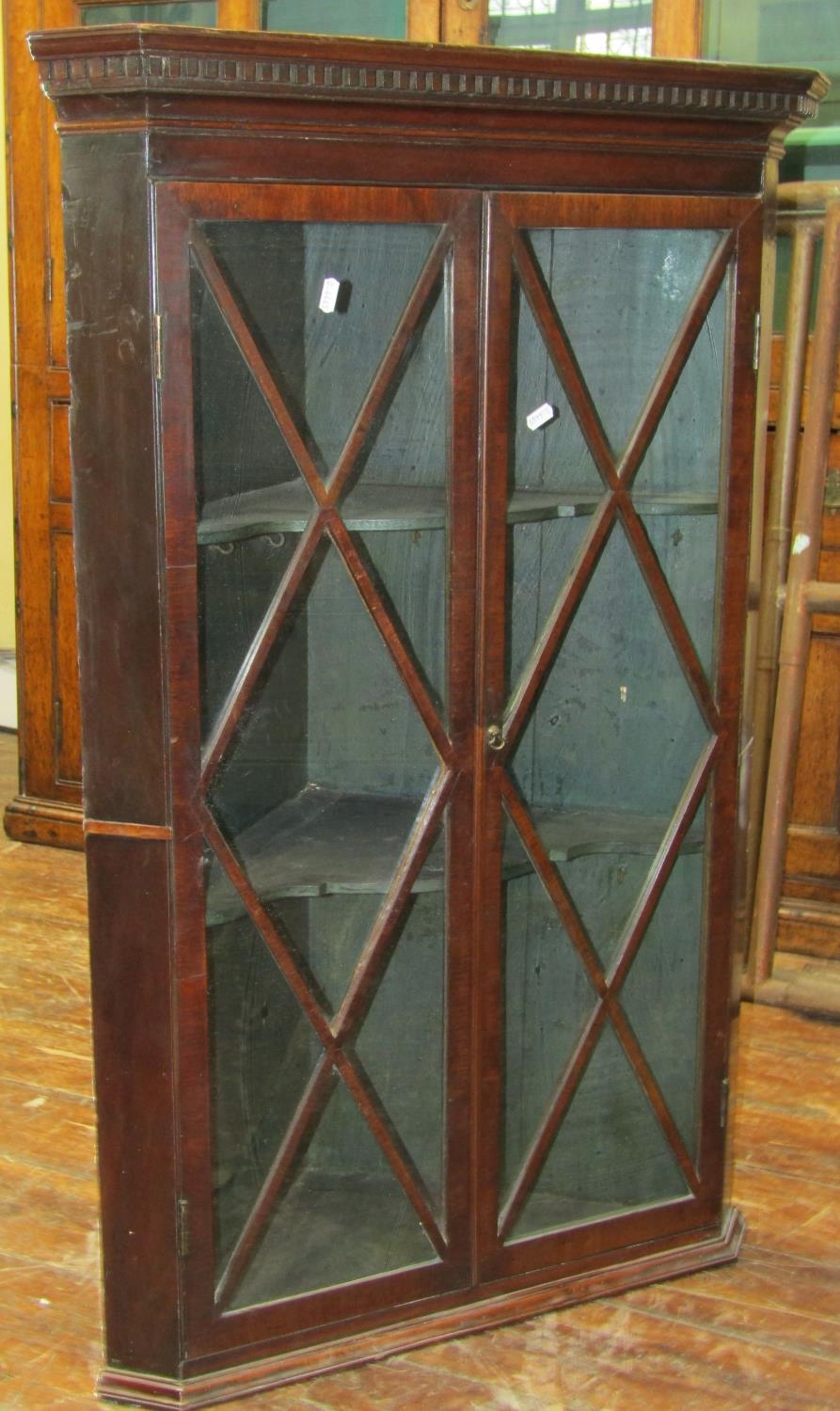 Georgian mahogany hanging corner cupboard with astragal glazed panelled doors enclosing a fitted and