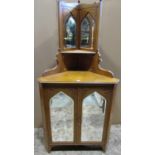 Victorian Gothic style light oak freestanding corner cabinet enclosing lancet shaped bevelled edge