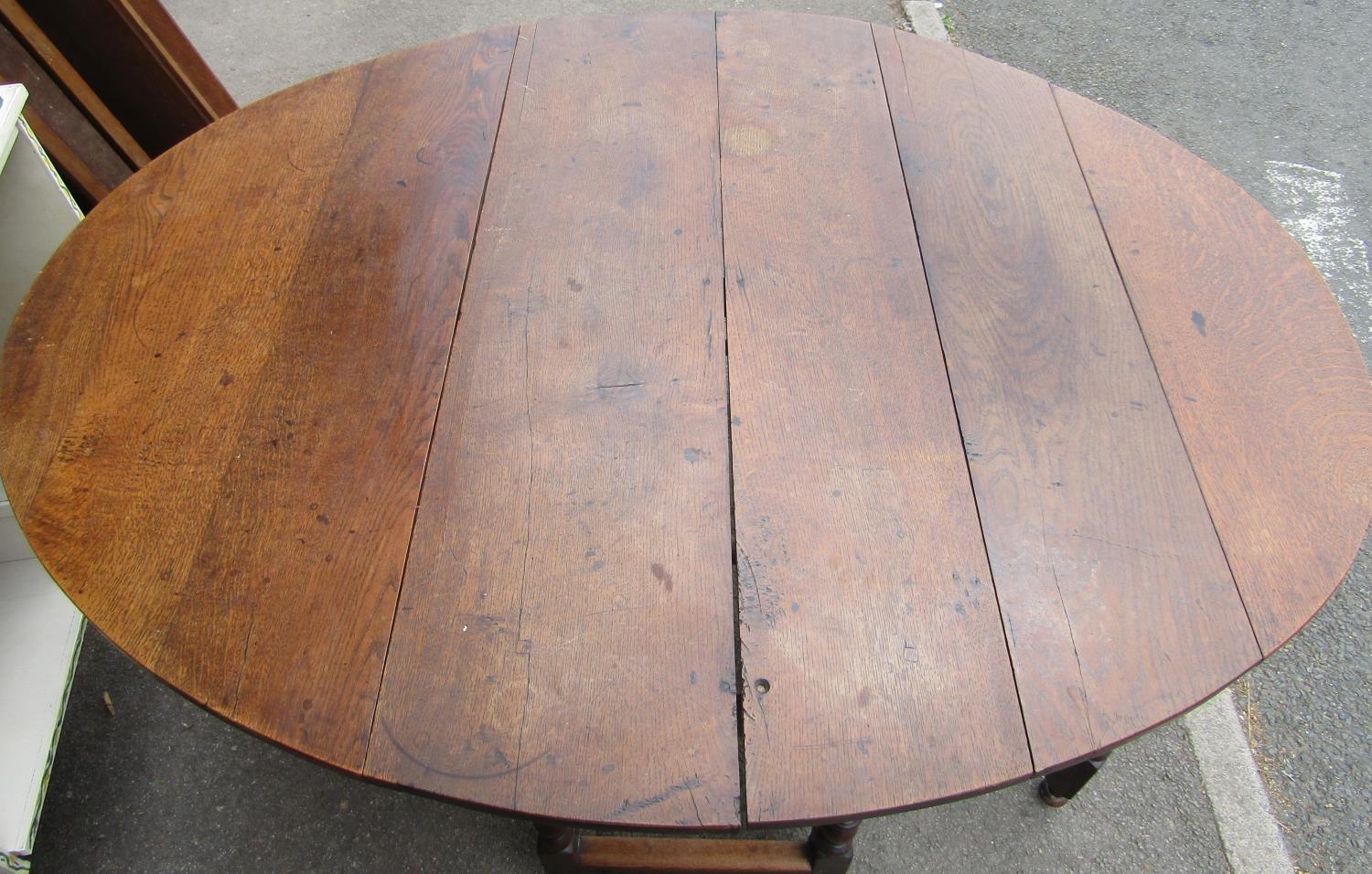 A Georgian oval drop leaf gateleg dining table, principally in oak, raised on six turned supports - Image 2 of 2