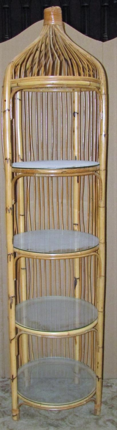 A floorstanding cane work open display unit of cylindrical form with four glass loose shelves, 190