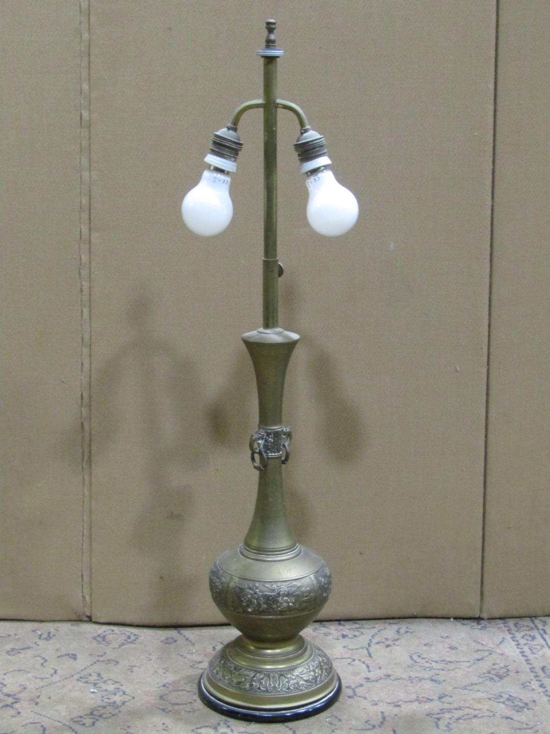 A Chinese cast brass table lamp raised on a circular ebonised base 83 cm (full height)