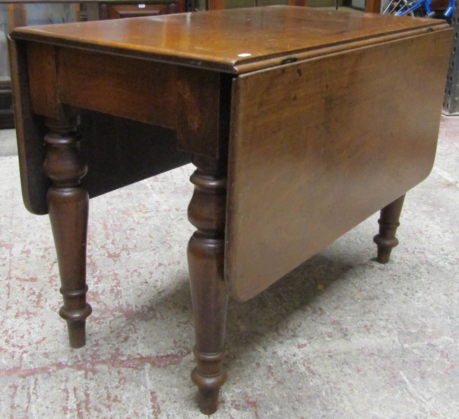 A 19th century mahogany drop leaf dining table on four turned supports, the top with swivel action