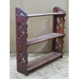 A three tier flight of Victorian open wall shelves with pierced fretwork detail, 60 cm wide x 15