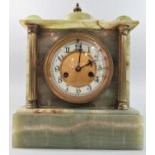 A late 19th century onyx mantel clock of classical form with brass supports enclosing an eight day
