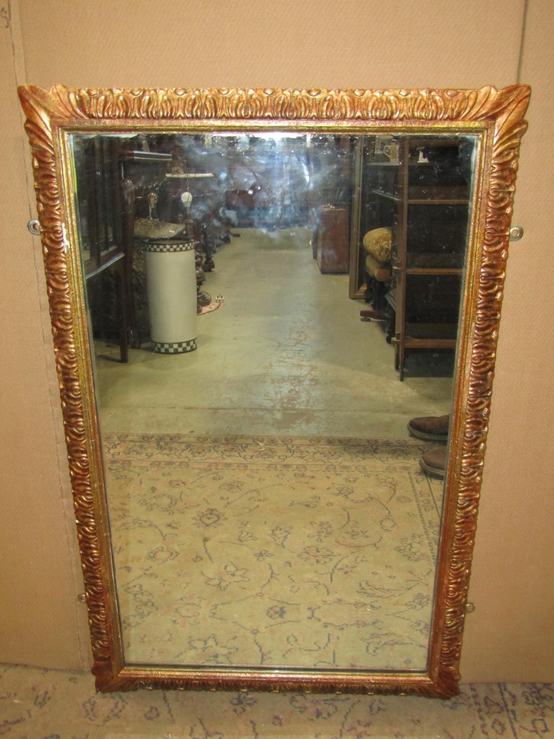 A rectangular gilt framed wall mirror with repeating foliate detail 86 cm x 55 cm