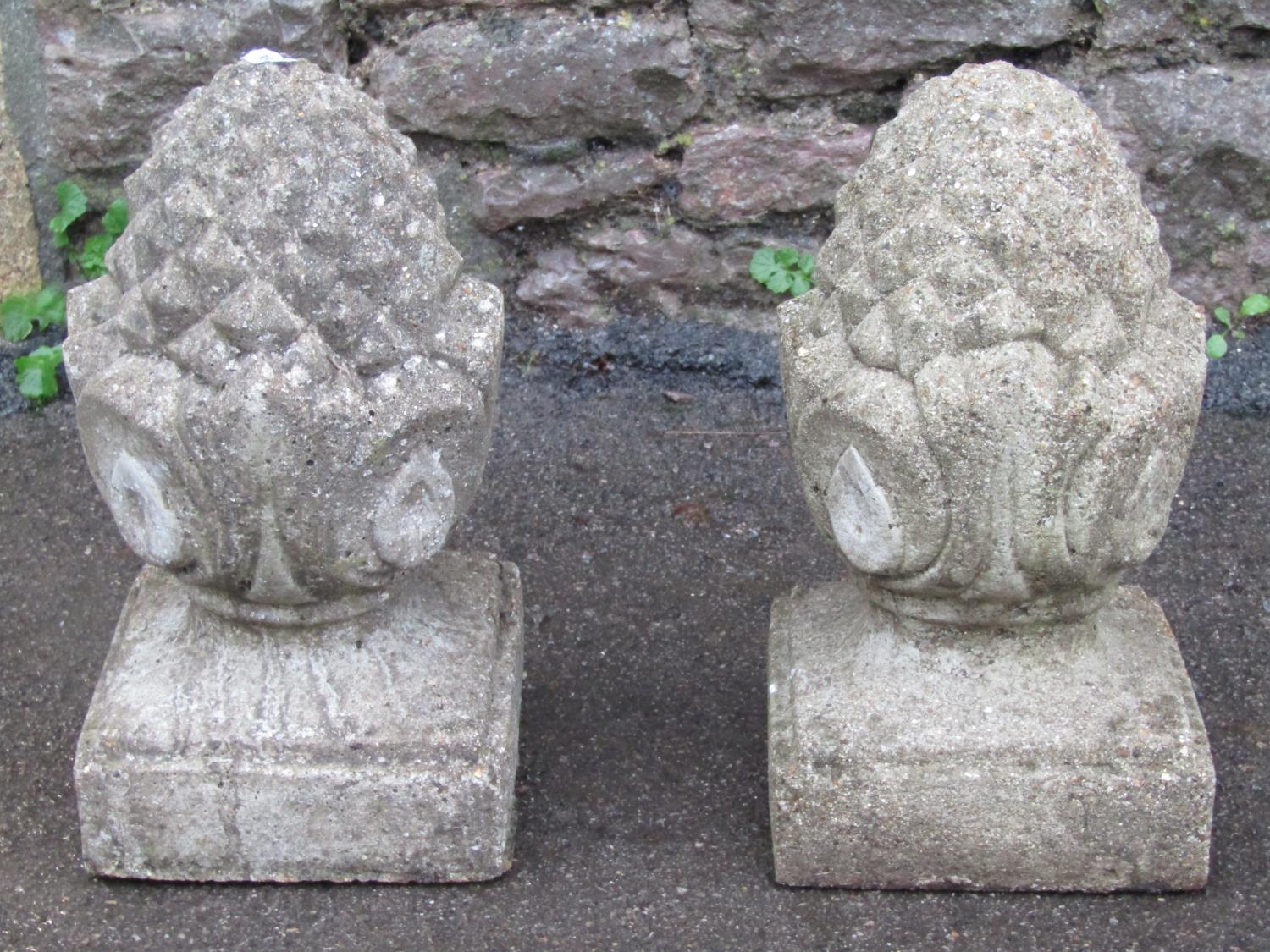 A pair of small cast composition stone pineapple pier cap finials, 32 cm high