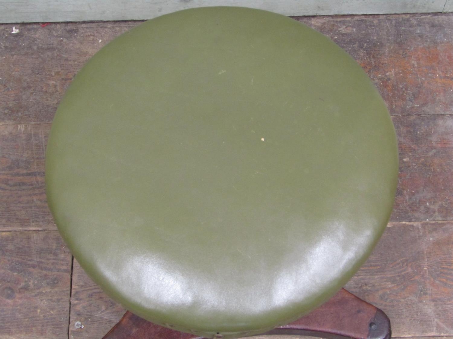 A William IV mahogany piano stool upholstered in green leather, raised on an adjustable column and - Image 2 of 2