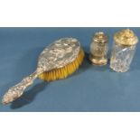 A silver backed hairbrush with a Bacchanalian decoration, a silver pepper grinder and a silver