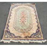 A Middle Eastern designed carpet with a central extended pink medallion and serrated surround on a
