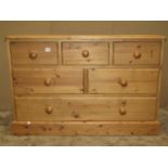 A modern stripped pine dresser fitted with an arrangement of six drawers set on a moulded plinth,