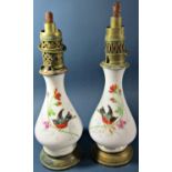 A pair oil lamps with decoratively painted glass bodies with colourful birds amongst flowers, five