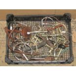 A small plastic crate containing a quantity of equine related bits, stirrups, etc