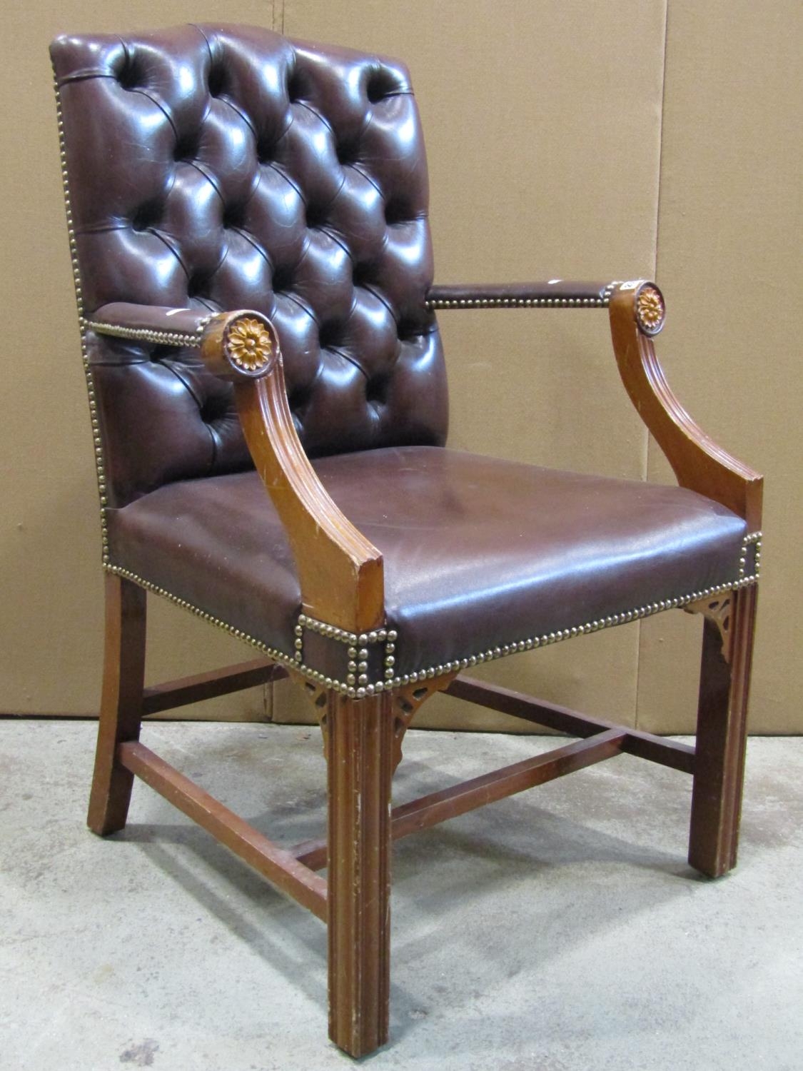 A reproduction Georgian style open armchair with dark brown faux leather upholstered seat and button