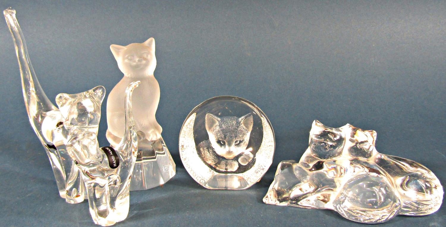 A collection of glass and crystal cats in various positions.