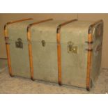 A vintage fibre and timber lathe bound cabin trunk with brass fittings and stitched leather strap