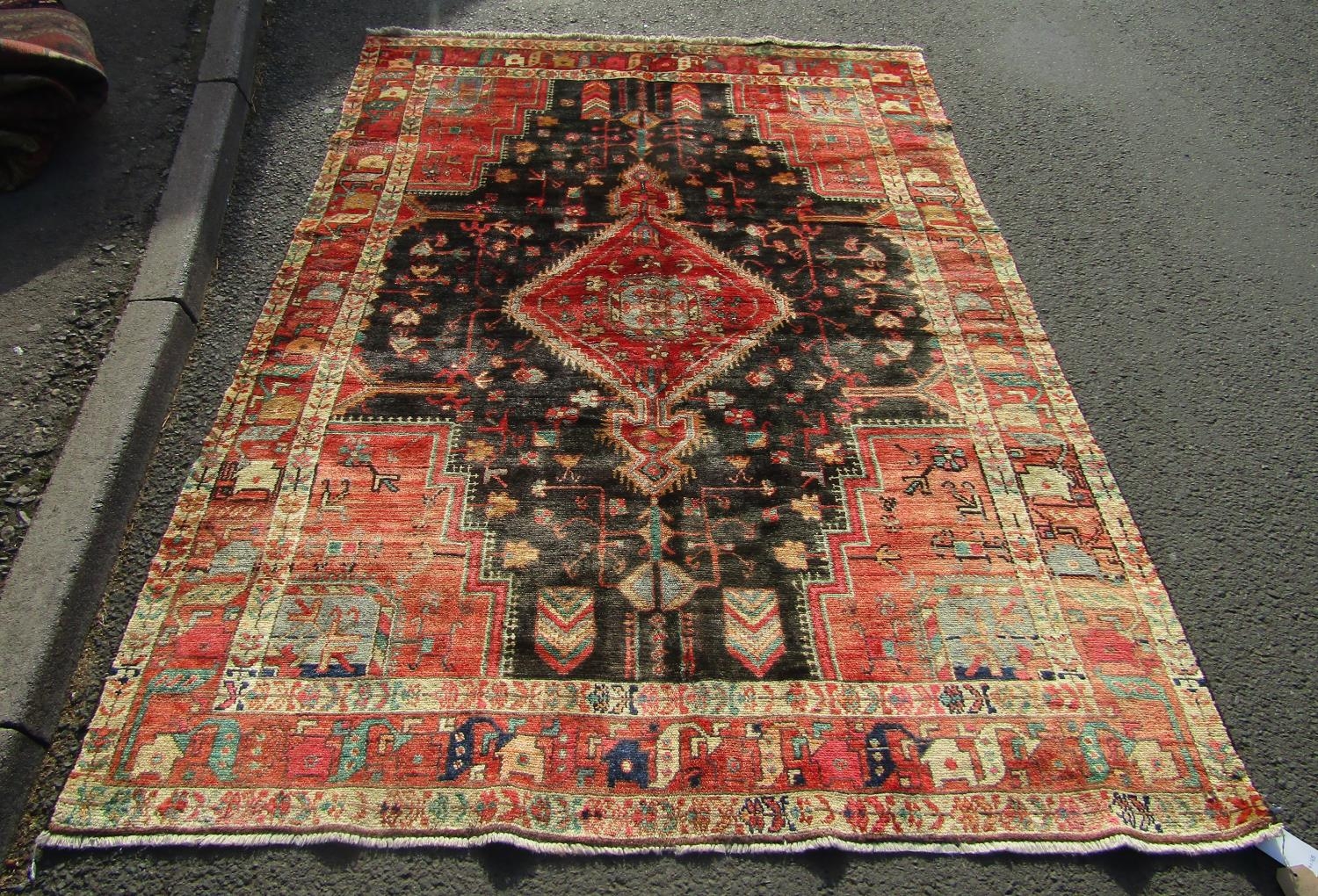 A North West Persian Nahawand rug with lozenge pole medallion and flower and branch motifs on a