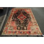 A North West Persian Nahawand rug with lozenge pole medallion and flower and branch motifs on a