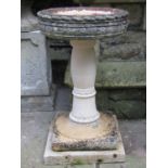 A weathered cast composition stone three sectional bird bath of circular form, 42 cm diameter x 71