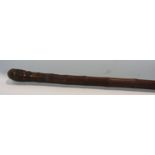 A intricately carved South East Asian bamboo pole 195cm long together with an ebony walking cane,