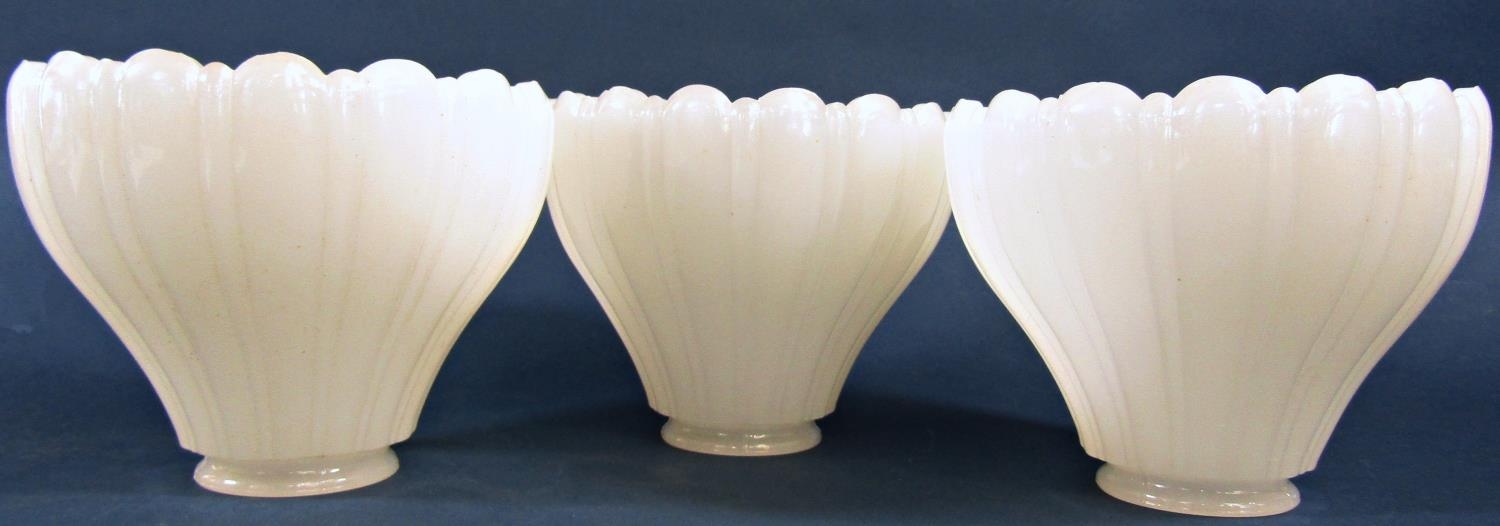 Three Vaseline moulded glass light shades with scalloped edge 12cm high x 14.5cm diam.