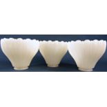 Three Vaseline moulded glass light shades with scalloped edge 12cm high x 14.5cm diam.