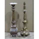 A carved wooden pricket candlestick 61 cm high together with a gilded table lamp with foliate and