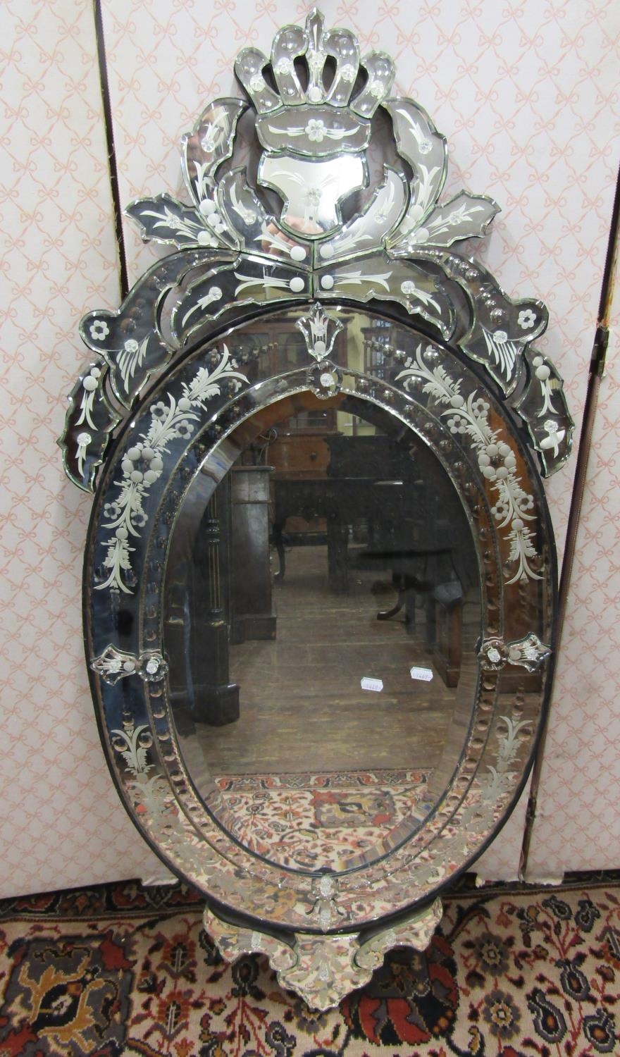 A Venetian style mirror with etched detail, set beneath a shaped and pierced pediment, 120cm high