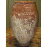 An old terracotta jar with thumb pressed mouldings, incised banded detail and traces of painted