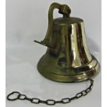 A wall hung brass bell with clapper