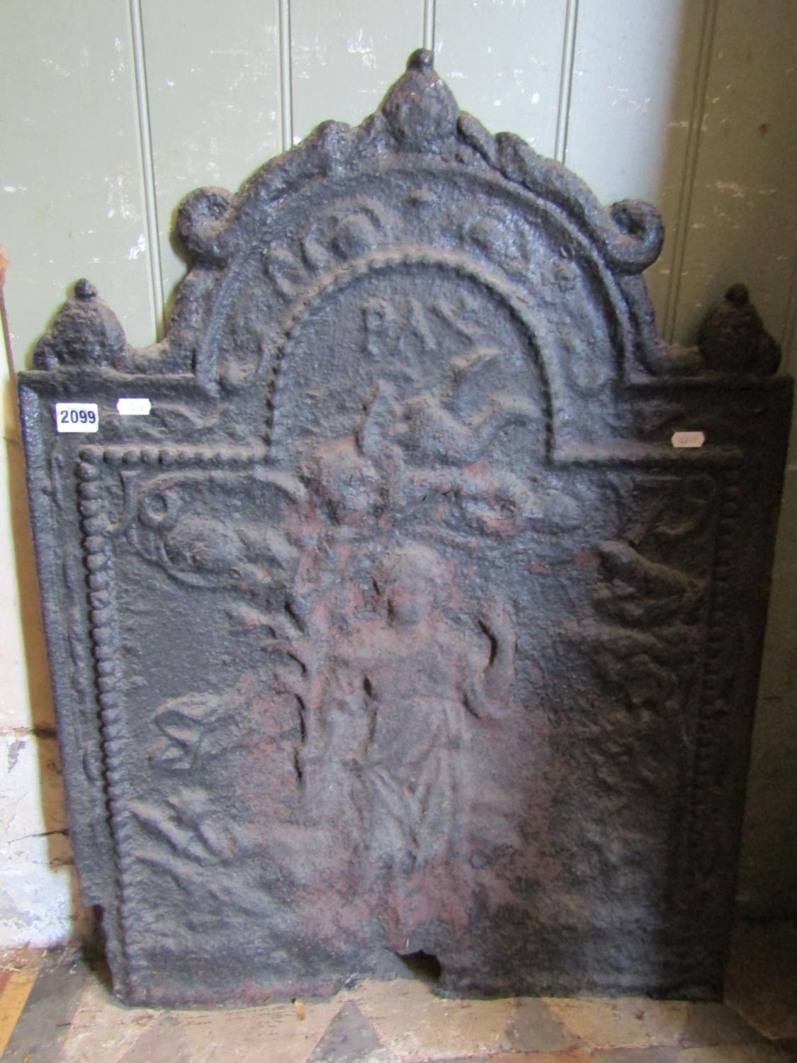 An antique cast iron fire back with raised relief detail of a maiden in a woodland setting dated